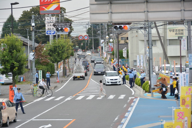 道路沿いに警察官や職員が並び街頭啓発をしている様子の写真