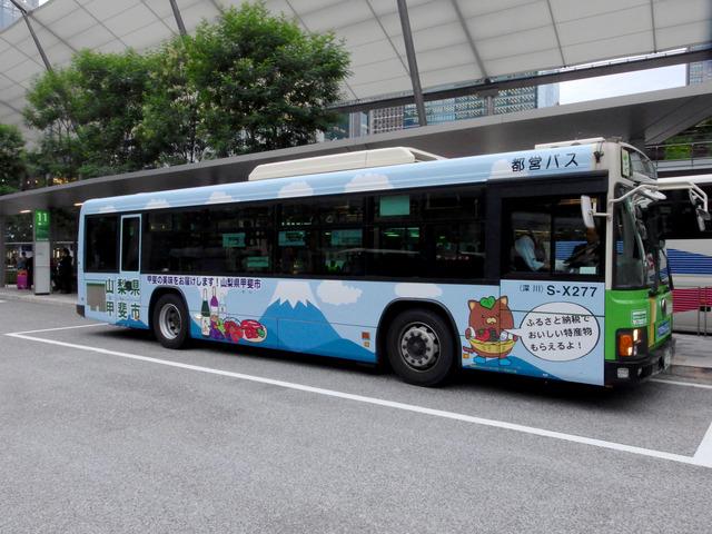 市営業部長「やはたいぬ」と特産品を配したレイアウトの「ふるさと納税PR編」のラッピングバスの写真