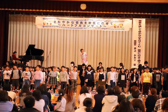 井上さんと児童が歌を歌っている写真