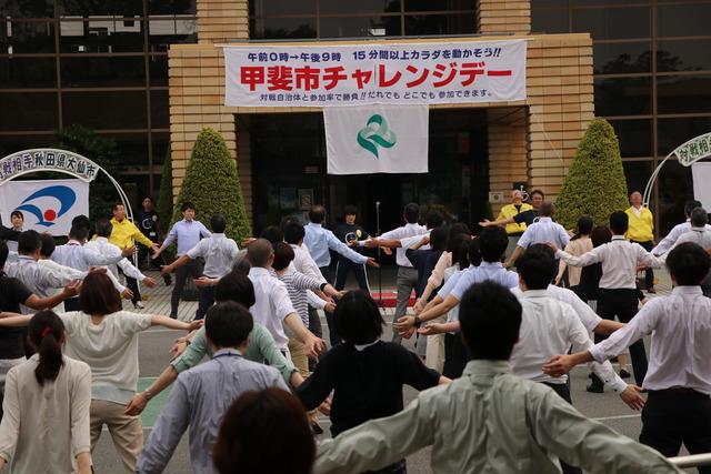 市役所前にてセレモニー参加者全員で甲州弁ラジオ体操第一をしている写真