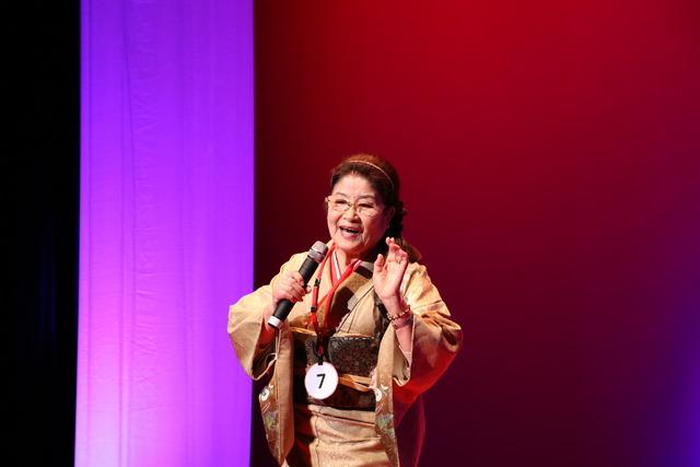 双葉ふれあい文化館にて舞台の上で参加ナンバー7番の女性の方が歌っている写真