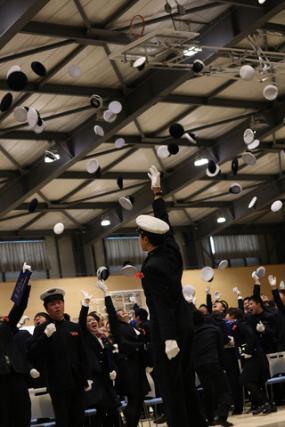 卒業生全体が天井に向かって帽子を投げている写真