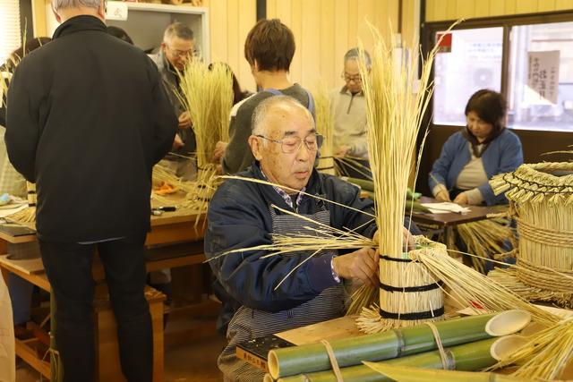 藁を編んでいる参加者の男性の写真