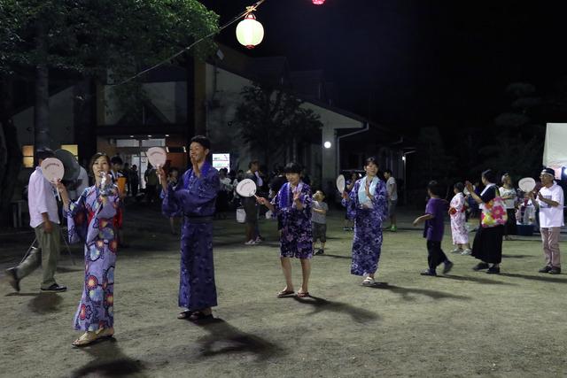 浴衣姿で盆踊りを楽しむ人々の写真