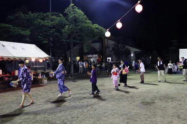 浴衣姿で盆踊りを楽しむ人々の写真