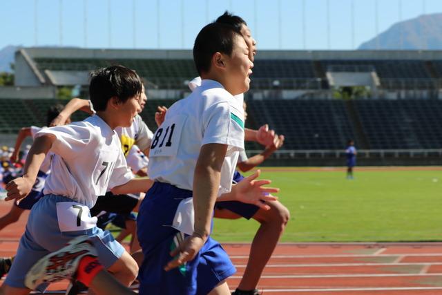 山梨中銀スタジアム陸上競技場にて男子児童たちの100メートル走の横からの写真