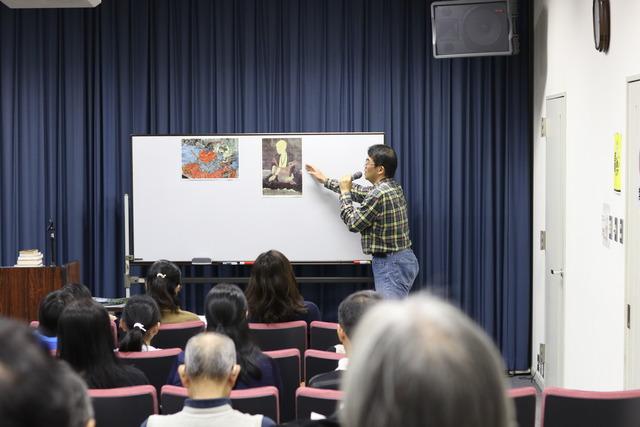 歴史講座「甲斐市で起こった逆転劇」の現場写真。先生がホワイトボールの上に貼っている画像を紹介している写真