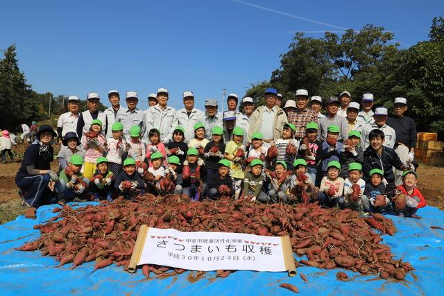 竜王北保育園の年長児と、市農業活性化協議会の皆さんの記念写真