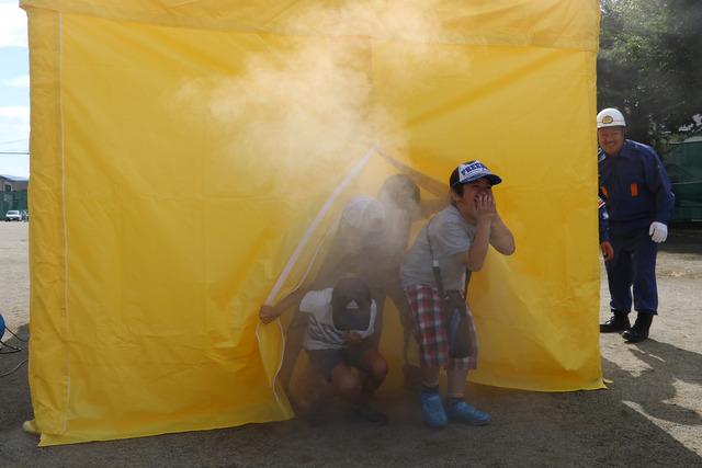 3人の子どもが煙が立ち込める黄色のブースから出てくる写真
