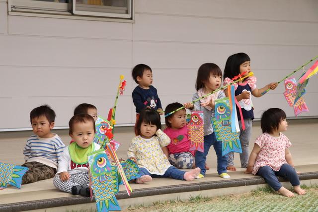 それぞれ小さい鯉のぼりを持っている幼い園児たちの写真