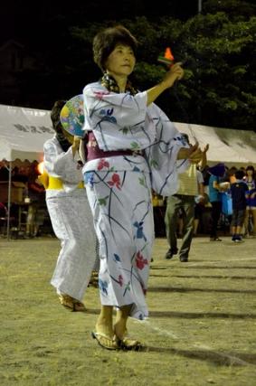 浴衣姿の女性が盆踊りを踊っている写真