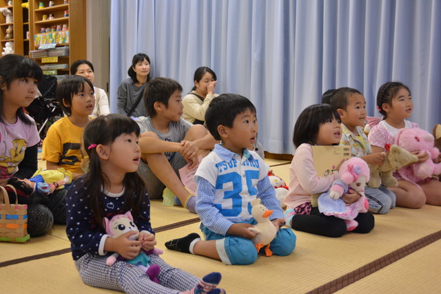 ぬいぐるみと一緒にお話会を楽しむ子どもたちの写真