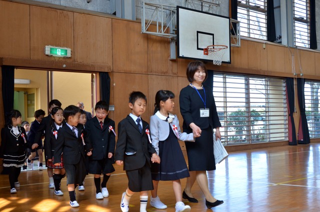 手をつないで会場へ入場する子どもたちの写真