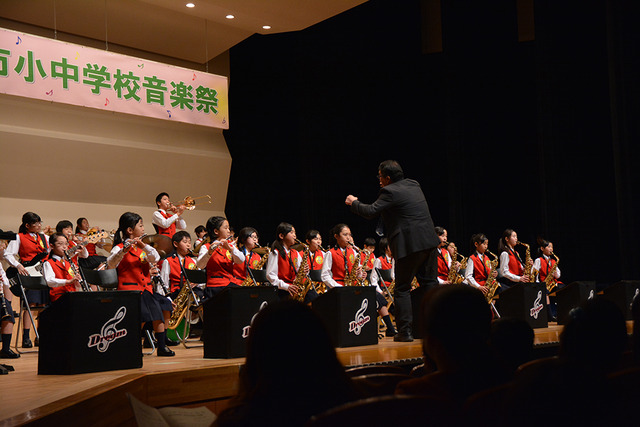 赤い衣装を着た敷島南小学校吹奏楽部の写真