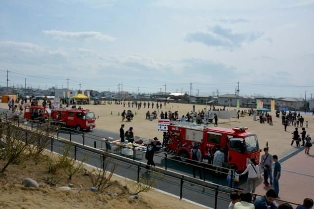 数台の消防車が停車し、人がたくさん集まっている島上条公園の写真