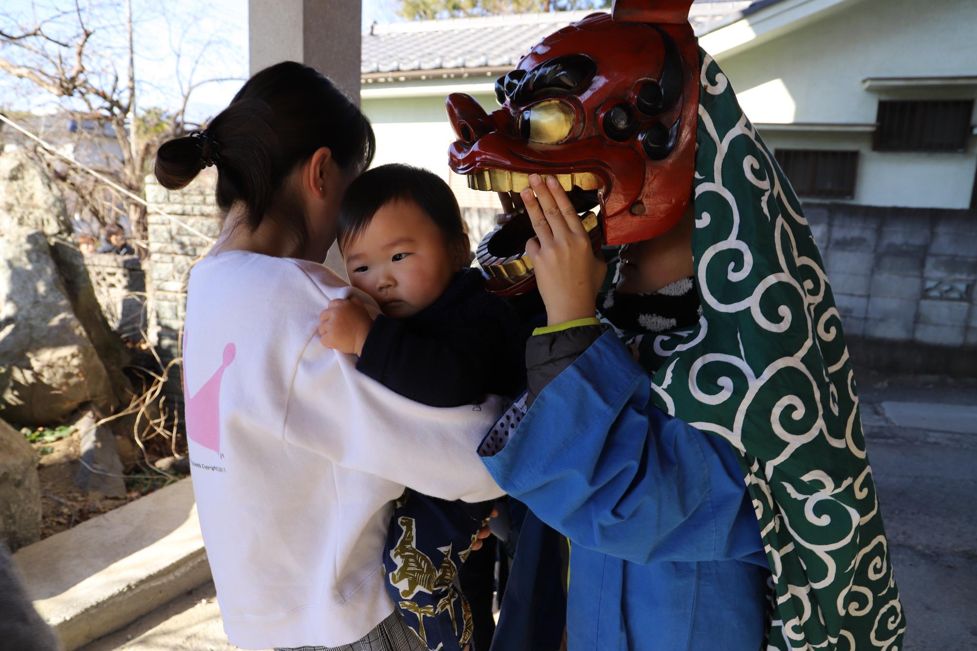 獅子舞に頭を噛んでもらう子ども