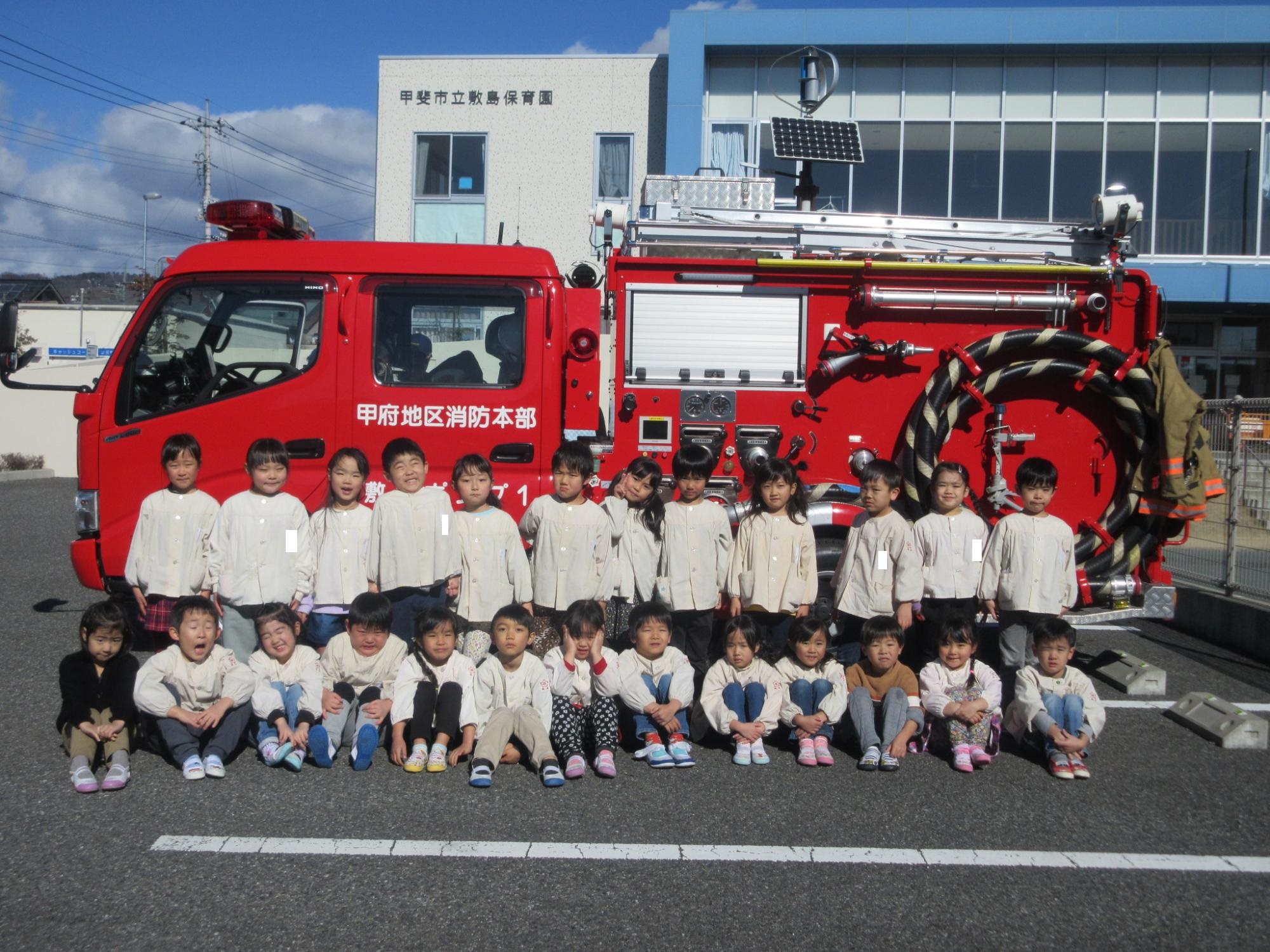 避難訓練にて消防車との集合写真