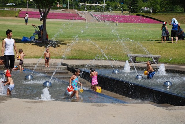 噴水で子どもたちが遊んでいる写真