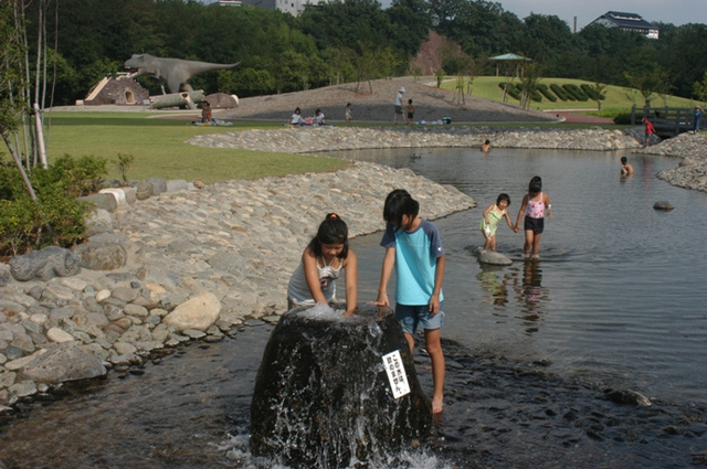 子供たちじゃぶじゃぶ池で水を遊んでいる写真