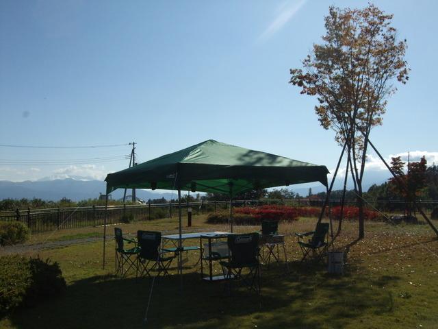 芝生の上に設置されたテントとバーベキューセットの写真