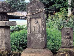 中央に半肉彫りの地蔵菩薩像、右側に造立銘、左側に紀年銘が刻まれている亀沢地蔵板碑の写真
