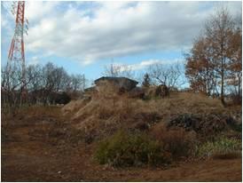 原っぱの中で丘のように盛り上がり草に覆われている狐塚2号墳の写真