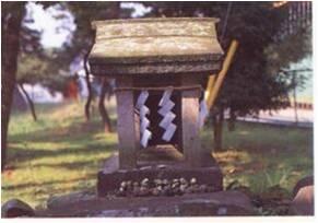 神明神社内にある古社水神宮の紙垂がついている石祠の写真