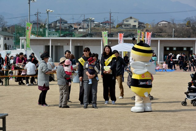 山梨クィーンビーズの選手が来場者に㏚を行っている写真