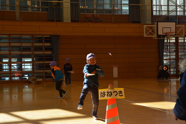 羽子板を持って笑顔で練習している男子児童の写真