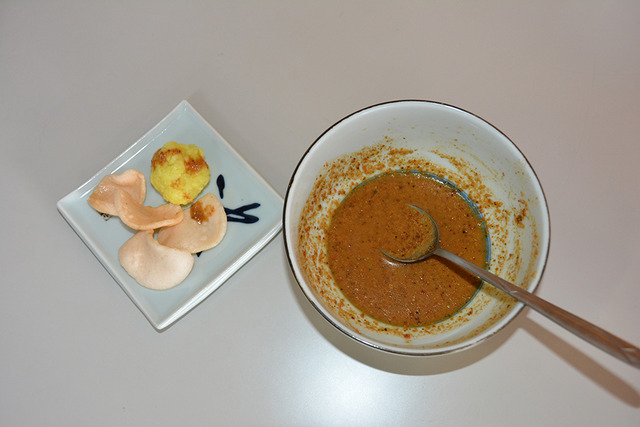 ターメリックライスとえびせんべい、そして香辛料が入ったナッツのソースの写真