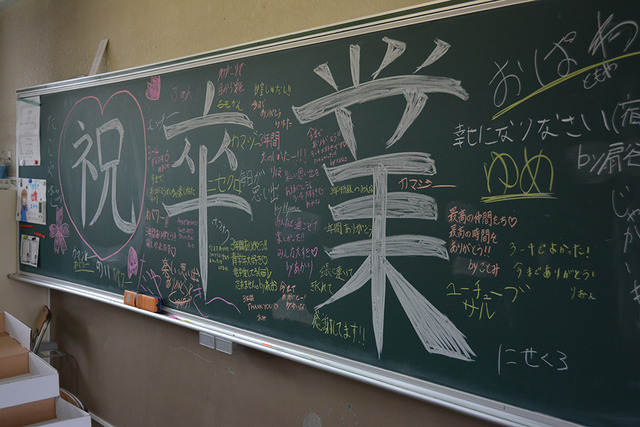 大きな文字で書かれた「祝卒業」の文字のまわりに、たくさんのメッセージが書かれている黒板の写真