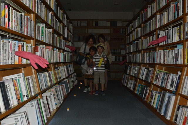 本棚から手が出てきて、怯える子供たちの写真
