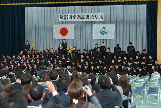 卒業生たちが舞台上に並んでいる様子の写真
