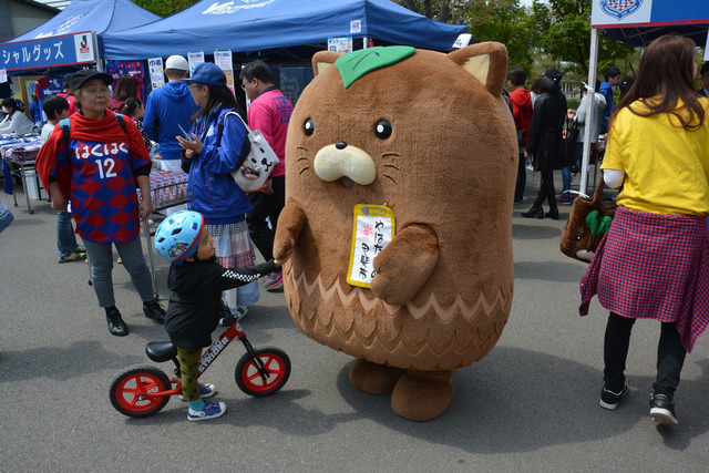 ゆるきゃら甲斐市営業部長のやはたいぬもが子供と触れ合う様子の写真