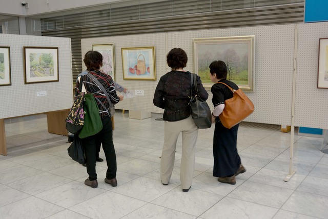 1階ロビーの水彩画を観覧する様子の人々の写真