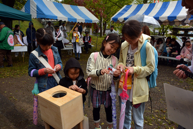 おみくじを引く子供たちの写真