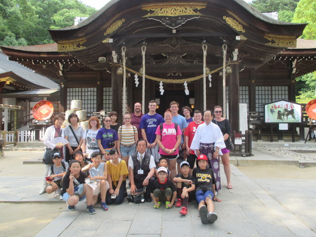 武田神社の本殿前で集合写真を撮るキオカック市の生徒と日本の生徒たちの写真