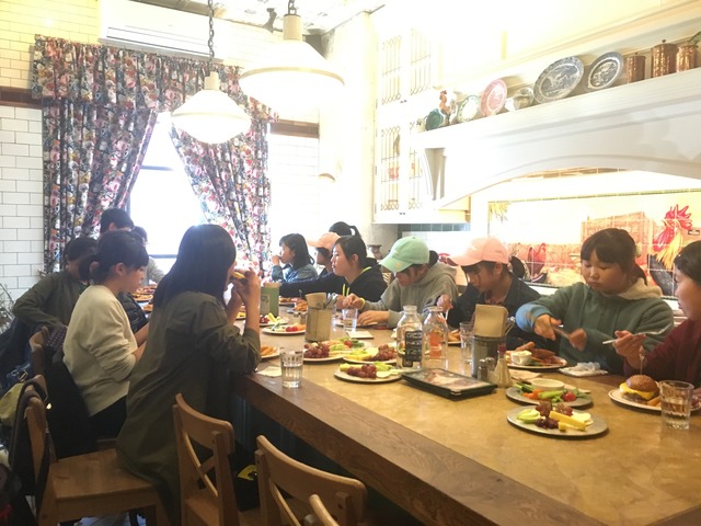 内装が凝ったカフェで食事をする訪問団のメンバーの写真