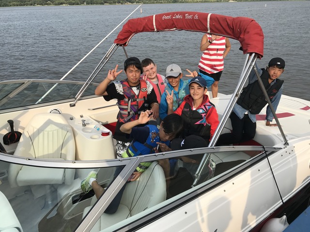 ヨットの上で現地の子どもたちと入り混じってピースサインをしている訪問団の写真