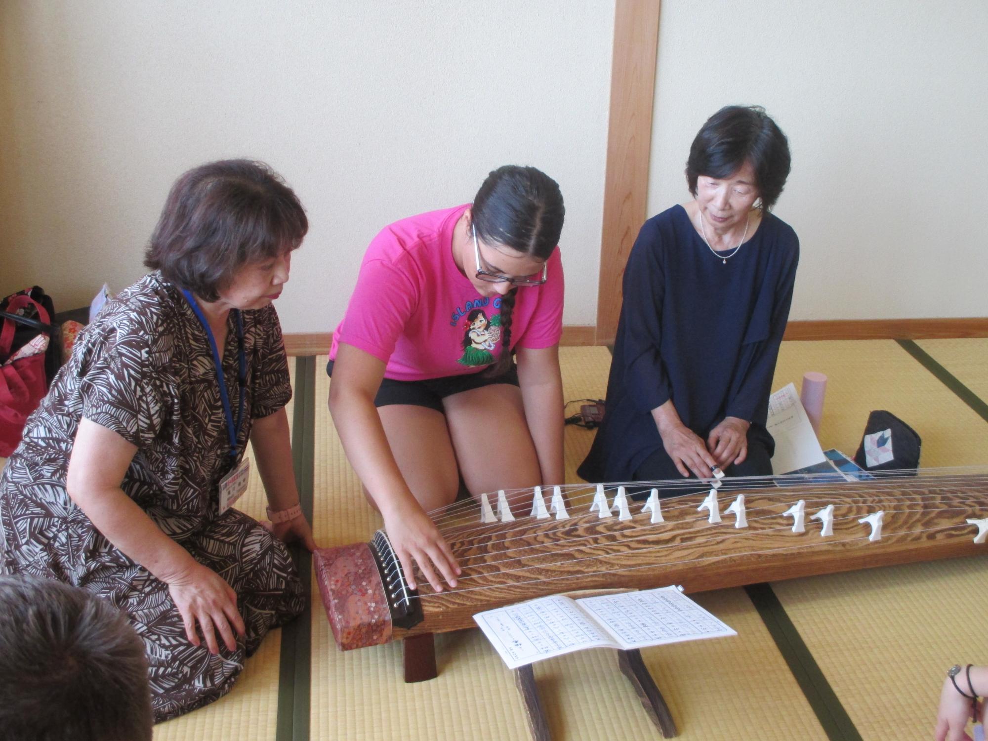 団員がお琴を体験している写真