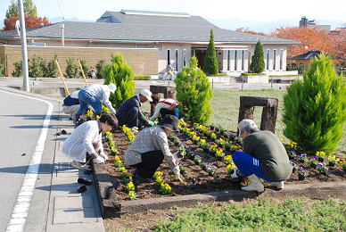 歴史公園で花壇に植える人々の写真