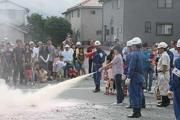 消防訓練を行う地域の人々の写真
