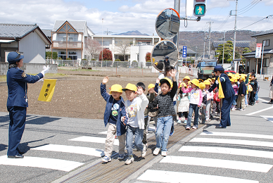 手を挙げて横断歩道を渡る児童たちの写真