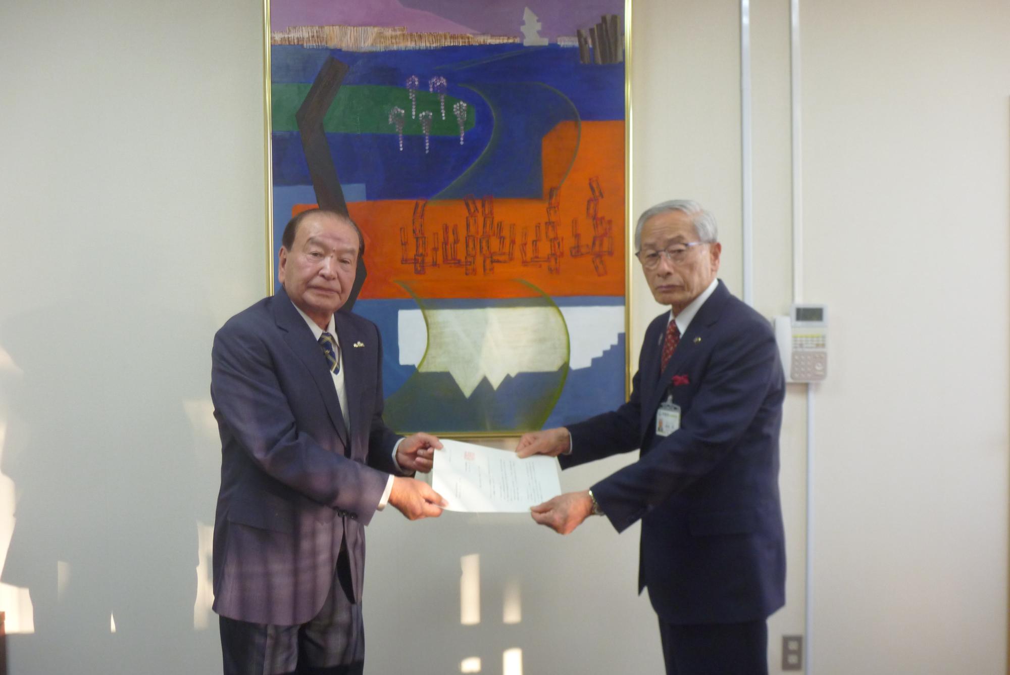 甲斐市水道審議会会長から市長に答申書を手渡している様子