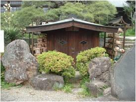 コンクリートの枠が作られその上を屋根が覆う湧水地の写真