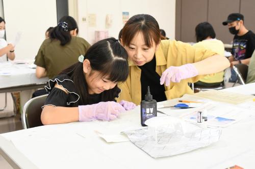 レジンの中にビーズなどを入れていく作業をしている写真