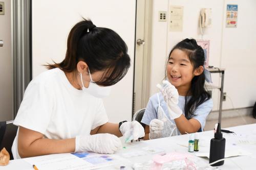 親子で笑いながら作業している写真