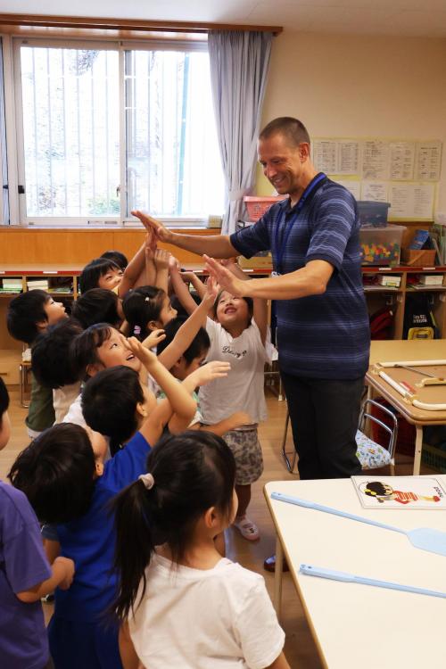 ハイタッチをする講師と子どもたちの写真