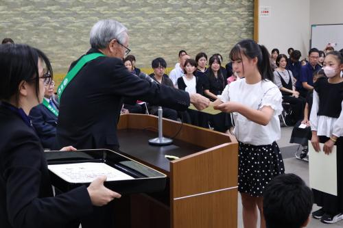 表彰状を受け取る小学校高学年の女子