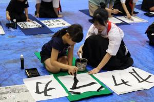 高校生に教えてもらいながら書く子ども